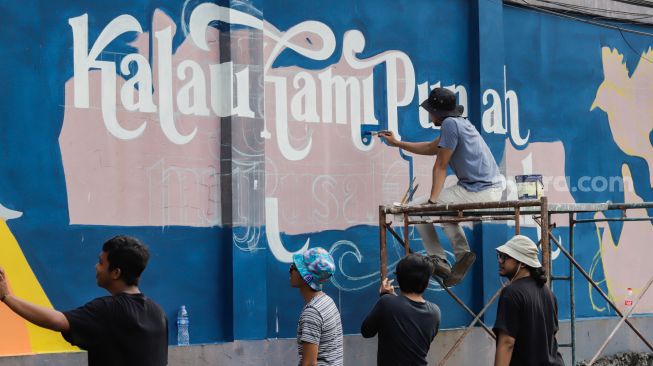 Para seniman menyelesaikan pembuatan mural tematik  di salah satu tembok di Taman Margasatwa Ragunan, Jakarta Selatan. Rabu (28/9/2022). [Suara.com/Alfian Winanto]