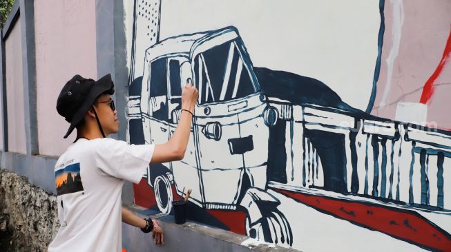 Para seniman menyelesaikan pembuatan mural tematik  di salah satu tembok di Taman Margasatwa Ragunan, Jakarta Selatan. Rabu (28/9/2022). [Suara.com/Alfian Winanto]