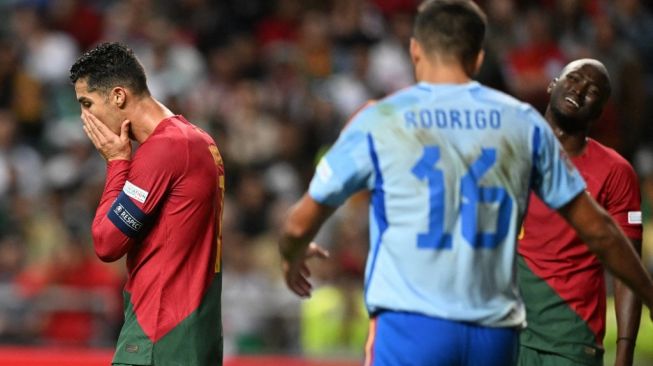 Ekspresi kekecewaan megabintang Timnas Portugal, Cristiano Ronaldo (kiri) pada laga UEFA Nations League kontra Spanyol di Braga, Rabu (28/9/2022) dini hari WIB. [PATRICIA DE MELO MOREIRA / AFP]