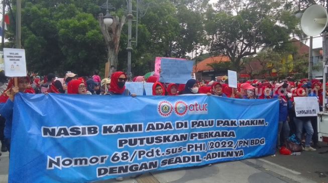 Ratusan buruh yang di PHK oleh PT Masterindo Jaya Abadi menutup Jalan LLRE Martadinata, Kota Bandung, Kamis (29/8/2022) sekira pukul 11.30 WIB. (Suara.com/M Dikdik RA)