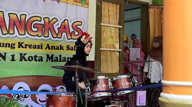 Siswi MIN 1 Kota Malang bermain drum pada pertunjukan Pangkas/ Panggung Kreasi Anak Salih (Foto: Aulia/Suara.com)