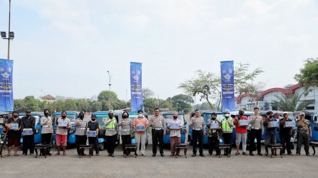 Bagikan Paket Sembako, Korlantas Pesankan Tertib Berlalu Lintas ke Supir Bajaj