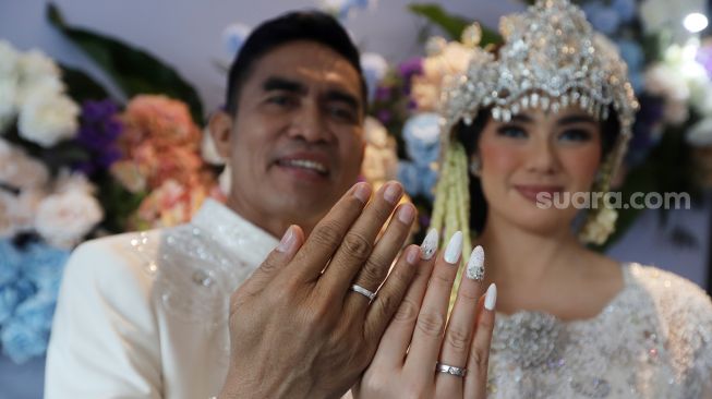 Catherine Wilson bersama suaminya Idham Mase menunjukan cincin kawain usai akad nikah di Jakarta, Sabtu (1/1). [ Suara.com/Oke Atmaja]