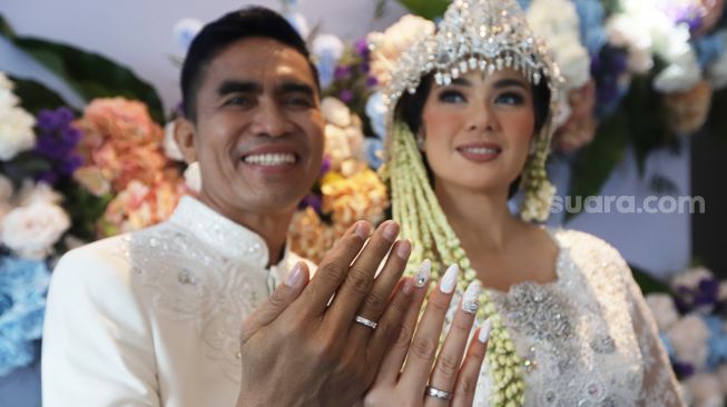 Catherine Wilson bersama suaminya Idham Massae menunjukan cincin kawin usai akad nikah di Jakarta, Sabtu (1/1). [ Suara.com/Oke Atmaja]