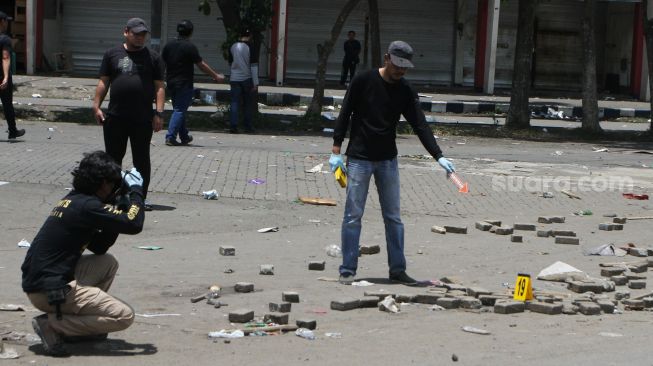 Anggota tim identifikasi gabungan dari Polres Malang dan Polda Jatim melakukan Olah Tempat Kejadian Perkara (TKP) kerusuhan di depan Stadion Kanjuruhan, Malang, Jawa Timur, Minggu (2/10/2022). [ANTARA FOTO/Ari Bowo Sucipto/foc]