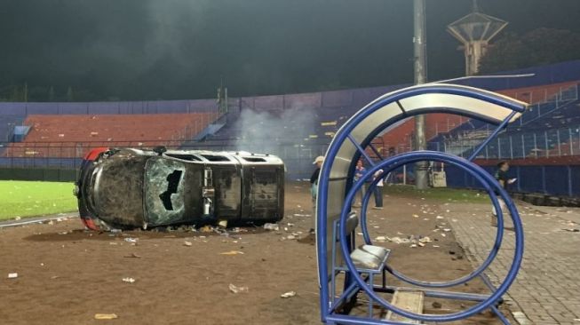 Sebuah mobil polisi rusak di lapangan Stadion Kanjuruhan, Kabupaten Malang, Jawa Timur, Sabtu (1/10/2022) malam, akibat kericuhan yang terjadi usai pertandingan antara Arema FC melawan Persebaya Surabaya. ANTARA/Vicki Febrianto