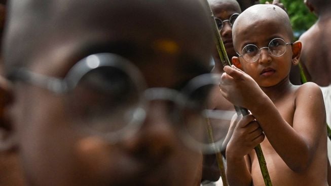 Anak-anak berpakaian menyerupai ikon kemerdekaan India Mahatma Gandhi dalam sebuah acara untuk memperingati kelahirannya kelahirannya di Chennai, India, Sabtu (1/10/2022). [Arun SANKAR / AFP]