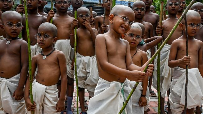 Anak-anak berpakaian menyerupai ikon kemerdekaan India Mahatma Gandhi dalam sebuah acara untuk memperingati kelahirannya kelahirannya di Chennai, India, Sabtu (1/10/2022). [Arun SANKAR / AFP]