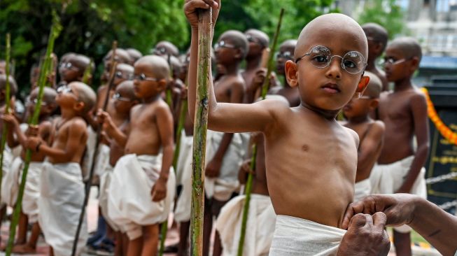 Anak-anak berpakaian menyerupai ikon kemerdekaan India Mahatma Gandhi dalam sebuah acara untuk memperingati kelahirannya kelahirannya di Chennai, India, Sabtu (1/10/2022). [Arun SANKAR / AFP]