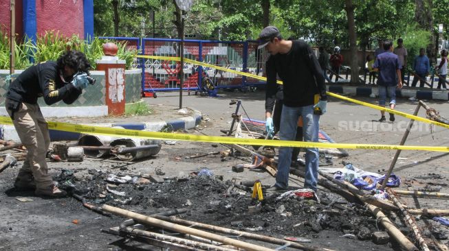 Anggota tim identifikasi gabungan dari Polres Malang dan Polda Jatim melakukan Olah Tempat Kejadian Perkara (TKP) kerusuhan di depan Stadion Kanjuruhan, Malang, Jawa Timur, Minggu (2/10/2022). [ANTARA FOTO/Ari Bowo Sucipto/foc]