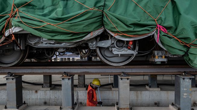 Pekerja berada di bawah rangkaian gerbong Kereta Cepat Jakarta-Bandung di Depo KCIC Tegalluar, Bandung, Jawa Barat, Sabtu (1/10/2022). [ANTARA FOTO/Aprillio Akbar/tom]
