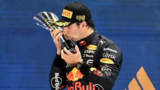 Pebalap tim Red Bull Sergio Perez melakukan selebrasi setelah memenangi Grand Prix Singapura di Sirkuit Marina Bay, Minggu (2/10/2022) (AFP/ROSLAN RAHMAN)