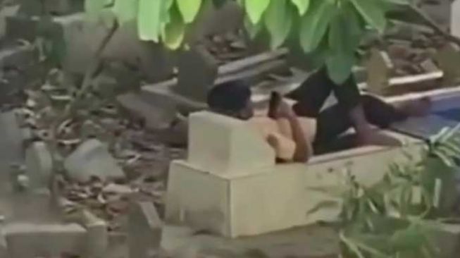 Bocah Santai Rebahan di Atas Makam Sambil Main HP: Sepertinya Lagi Bucin Berat