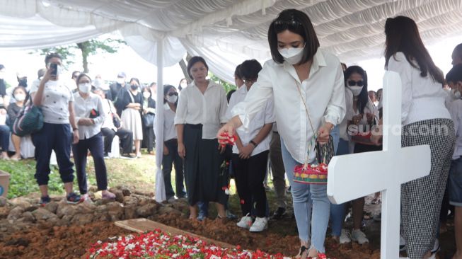 Gisella Anastasia melakukan tabur bunga di pusara merupakan ibunda Gading Marten, Farida Sabtijastuti, di TPU Tanah Kusir, Jakarta, Senin (3/10/2022). [Suara.com/Oke Atmaja]