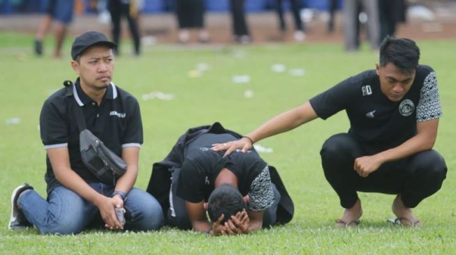 Para pemain Aremania saat berada di tengah lapangan mengenang para korban Tragedi Kanjuruhan [Foto: ANTARA]