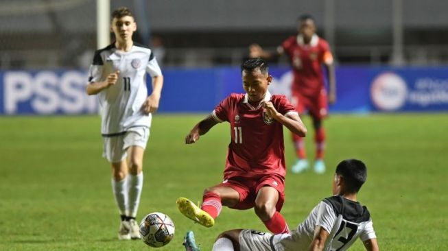 Pesepak bola Timnas Indonesia U-17 Riski Afrisal (atas) berebut bola dengan pesepak bola Timnas Guam U-17 Nicholas Moore (bawah) dalam laga Grup B Kualifikasi Piala Asia U-17 2023 di Stadion Pakansari, Cibinong, Kabupaten Bogor, Jawa Barat, Senin (3/10/2022). ANTARA FOTO/Aditya Pradana Putra/foc.