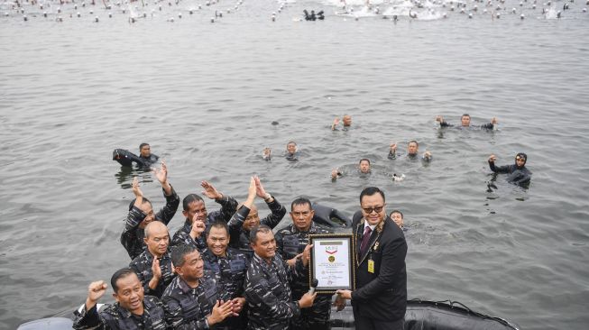 Komandan Korps Marinir Mayjen TNI (Mar) Widodo Dwi Purwanto (ketiga kanan) menerima penghargaan Rekor MURI dari Direktur Pemasaran MURI Awan Rahargo usai mengikuti 'Water Trappen' atau mengapung dalam air tanpa berpindah tempat di Perairan Pantai Marina, Jakarta, Rabu (5/10/2022). [ANTARA FOTO/M Risyal Hidayat/nz]