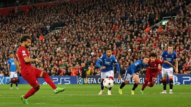 Striker Liverpool asal Mesir Mohamed Salah (kiri) menembak dari titik penalti untuk mencetak gol kedua timnya selama matchday ketiga Grup A Liga Champions antara Liverpool vs Rangers di Anfield di Liverpool, barat laut Inggris pada 4 Oktober 2022.Nigel Roddis / AFP.