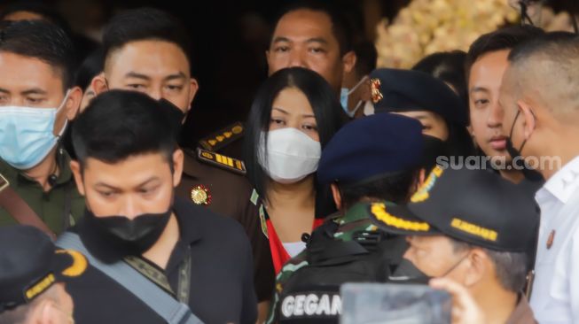 Istri Ferdy Sambo, Putri Candrawathi (tengah) dikawal petugas menuju kendaraan taktis saat proses pelimpahan berkas perkara tahap dua kasus pembunuhan Brigadir J di Gedung Kejaksaan Agung, Jakarta Selatan, Rabu (5/10/2022). [Suara.com/Alfian Winanto]