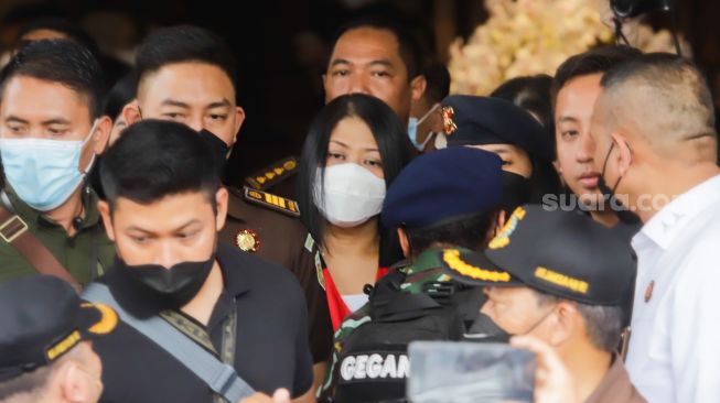 Istri Ferdy Sambo, Putri Candrawathi (tengah) dikawal petugas menuju kendaraan taktis saat proses pelimpahan berkas perkara tahap dua kasus pembunuhan Brigadir J di Gedung Kejaksaan Agung, Jakarta Selatan, Rabu (5/10/2022). [Suara.com/Alfian Winanto]