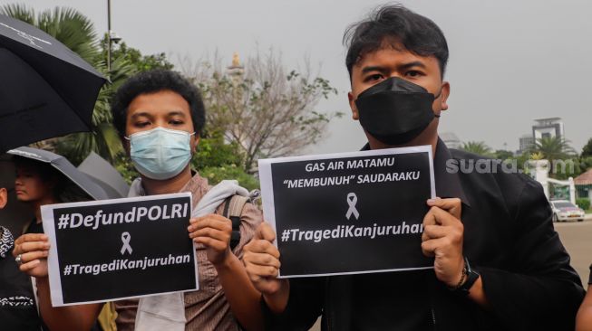 Pegiat Hak Asasi Manusia (HAM) membawa poster dan spanduk Arema saat aksi Kamisan di depan Istana Merdeka, Jakarta Pusat, Kamis (6/10/2022).
[Suara.com/Alfian Winsnto]