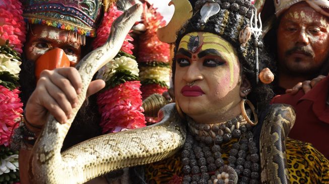 Seorang seniman berpakaian sebagai Dewa Siwa mengambil bagian dalam prosesi keagamaan saat festival Hindu Dussehra di Amritsar, India, Rabu (5/10/2022). [Narinder NANU / AFP]