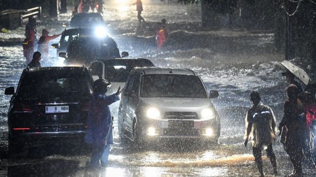 Sejumlah petugas Penanganan Prasarana dan Sarana Umum (PPSU) membantu warga menerjang banjir di kawasan Jeruk Purut, Jakarta Selatan, Kamis (6/10/2022). [ ANTARA FOTO/M Risyal Hidayat/YU]