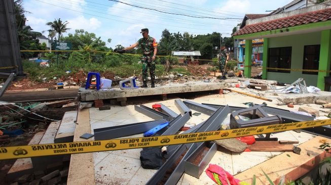 Prajurit TNI mengamati tembok roboh akibat banjir di MTSN 19 Pondok Labu, Jakarta, Jumat (7/10/2022).[ANTARA FOTO/Reno Esnir/nym].