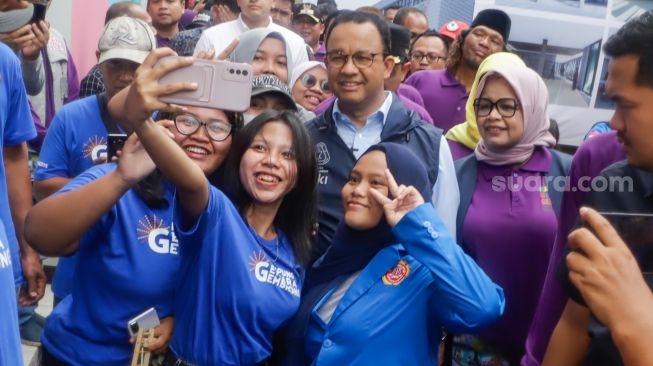 Gubernur DKI Jakarta Anies Baswedan (tengah) berswafoto dengan warga saat peresmian Kampung Gembira Gembrong di Jatinegara, Jakarta Timur, Jumat (7/10/2022). [Suara.com/Alfian Winanto]