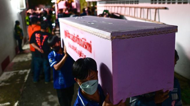 Personel penyelamat membawa peti mati korban korban penembakan massal di kamar mayat rumah sakit di Udon Thani, Thailand, Kamis (6/10/2022). [Manan VATSYAYANA / AFP]
