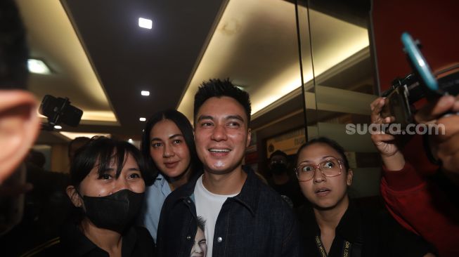 Baim Wong and his wife, Paula Verhoeven after being questioned by the South Jakarta Police, Jakarta, Friday (7/10). [Suara.com/Oke Atmaja]