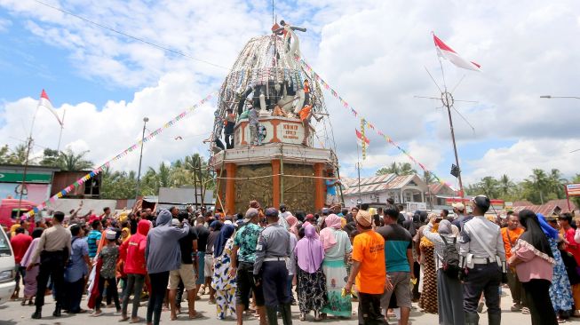 Sejumlah warga berebut aneka kudapan yang digantung di Tolangga atau wadah besar di Tibawa, Kabupaten Gorontalo, Gorontalo, Sabtu (8/10/2022).  ANTARA FOTO/Adiwinata Solihin