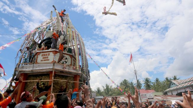 Sejumlah warga berebut aneka kudapan yang digantung di Tolangga atau wadah besar di Tibawa, Kabupaten Gorontalo, Gorontalo, Sabtu (8/10/2022).  ANTARA FOTO/Adiwinata Solihin