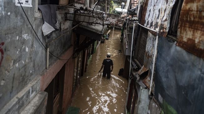 Warga berjalan melintasi banjir di permukiman penduduk kawasan Rawajati, Jakarta, Senin (10/10/2022). ANTARA FOTO/Aprillio Akbar/aww].