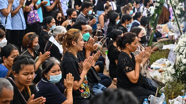 Keluarga korban berkumpul untuk doa bersama dan upacara keagamaan di luar tempat penitipan anak, yang menjadi lokasi penembakan massal di kota Uthai Sawan, Nong Bua Lam Phu, Thailand, Minggu (9/10/2022). [Lillian SUWANRUMPHA / AFP]