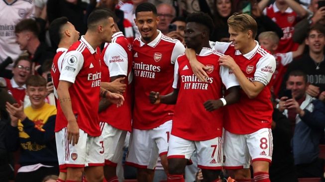 Para pemain Arsenal merayakan gol penyerang sayap Bukayo Saka (kedua dari kanan) ke gawang Liverpool pada laga Liga Inggris di Stadion Emirates, London, Minggu (9/10/2022) malam WIB. [ADRIAN DENNIS / AFP]