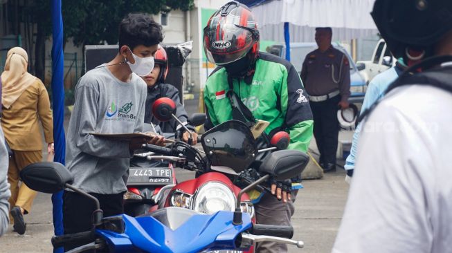 Pengemudi  kendaraan bermotor mengantri untuk mengikuti uji emisi di  Terminal Blok M, Jakarta Selatan, Selasa (11/10/2022). [Suara.com/Alfian Winanto]