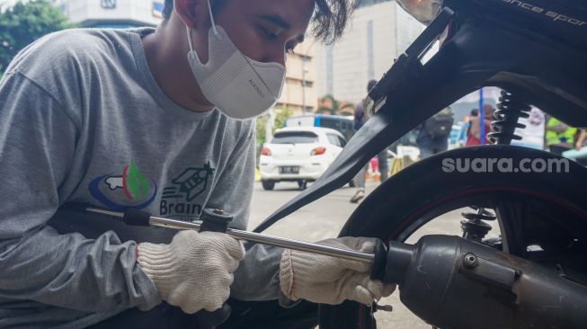 Petugas melakukan uji emisi kendaraan bermotor di  Terminal Blok M, Jakarta Selatan, Selasa (11/10/2022). [Suara.com/Alfian Winanto]