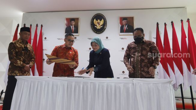 Menteri Koordinator Bidang Pembangunan Manusia dan Kebudayaan Muhadjir Effendy (kiri)  Menteri Pendayagunaan Aparatur Negara dan Reformasi Birokrasi (PANRB) Abdullah Azwar Anas (kanan), Menteri Ketenagakerjaan Ida Fauziyah (dua kanan) dan Menteri Agama Yaqut Cholil Qoumas (kanan) menandatangani Surat Keputusan Bersama (SKB) Libur Nasional dan Cuti Bersama 2023 di Kantor Kemenko PMK, Jakarta, Selasa (11/10/2022). [Suara.com/Oke Atmaja]
