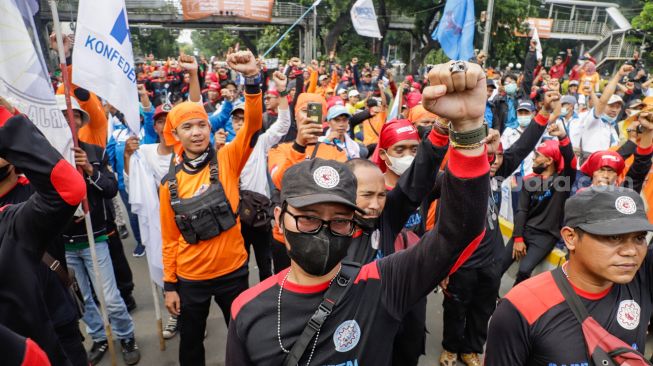 Massa buruh menggelar aksi unjuk rasa di Kawasan Patung Kuda, Jakarta Pusat, Rabu (12/10/2022). [Suara.com/Alfian Winanto]