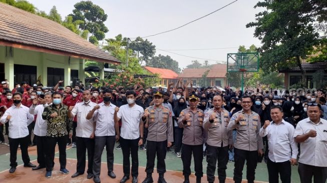 Jajaran Polres Metro Bekasi Kota dan siswa/siswi SMKN 9 Kota Bekasi sedang melakukan apel  terkait penyuluhan tentang bahaya tawuran (Suara.com / Danan Arya)