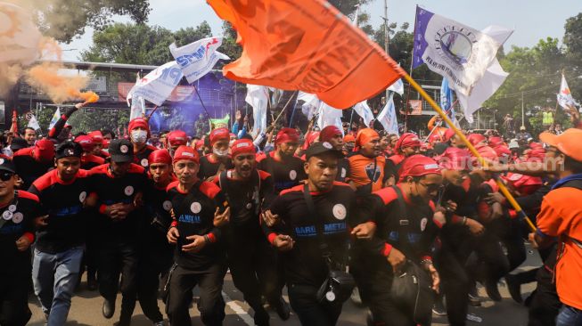 Massa buruh menggelar aksi unjuk rasa di Kawasan Patung Kuda, Jakarta Pusat, Rabu (12/10/2022). [Suara.com/Alfian Winanto]