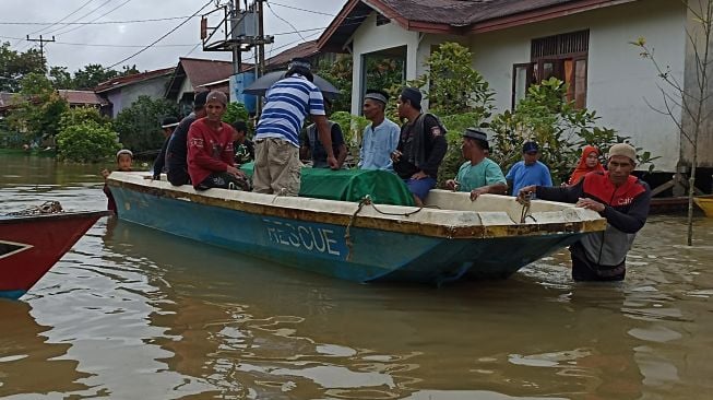 Sejumlah warga membawa jenazah untuk dimakamkan dengan menggunakan perahu saat melintasi banjir di Teluk Barak, Kelurahan Kedamin Hilir, Kecamatan Putussibau Selatan, Kabupaten Kapuas Hulu, Kalimantan Barat, Selasa (11/10/2022).  ANTARA FOTO/Teofilusianto Timotius