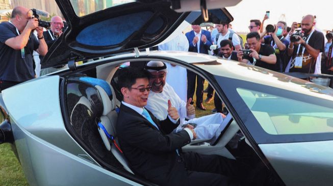 Presiden dan CEO Dubai Chambers Hassan Al Hashemi (kanan) dengan seorang tamu menaiki mobil terbang listrik Xpeng X2 selama pameran teknologi GITEX di Dubai, Uni Emirat Arab, Senin (10/10/2022). [Dubai Chambers / AFP]
