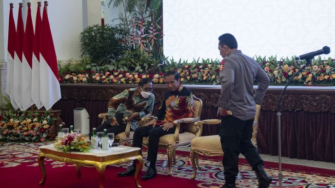 Presiden Joko Widodo (tengah) berbincang dengan Menko Polhukam Mahfud MD (kiri) usai Kapolri Jenderal Pol Listyo Sigit Prabowo memberikan sambutan di Istana Negara, Jakarta, Jumat (14/10/2022). [ANTARA FOTO/Sigid Kurniawan/tom].