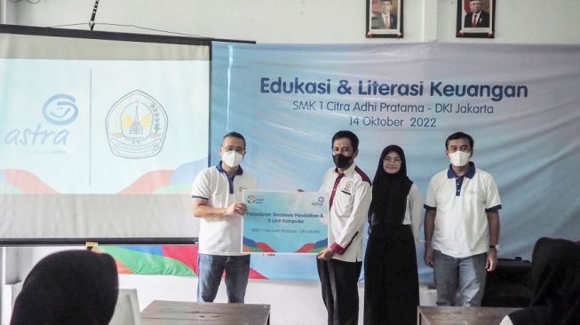 Operation Director Asuransi Astra, Hendry Yoga (kiri) bersama Compliance & Risk Management Director Asuransi Astra, YME Adi Sepiarso (kanan) saat penyerahan bantuan secara simbolis kepada Kepala Sekolah SMK 1 Citra Adhi Pratama, Drs Muhammad dan pelajar penerima beasiswa [Asuransi Astra].