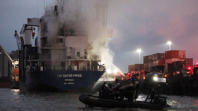 Kapal tunda (tug boat) memadamkan api yang membakar kapal kargo LIT Enterprise di Dermaga Jamrud Selatan, Pelabuhan Tanjung Perak, Surabaya, Jawa Timur, Kamis (13/10/2022). ANTARA FOTO/Didik Suhartono