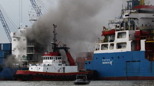 Petugas pemadam kebakaran memadamkan api yang membakar kapal kargo LIT Enterprise di Dermaga Jamrud Selatan, Pelabuhan Tanjung Perak, Surabaya, Jawa Timur, Kamis (13/10/2022).  ANTARA FOTO/Didik Suhartono