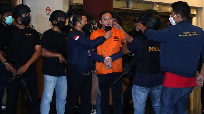 Petugas kepolisian memperlihatkan tersangka bandar besar judi online Apin Bak Kim alias Apin BK setibanya dari Malaysia di Bandara Soekarno Hatta, Tangerang, Banten, Jumat (14/10/2022).ANTARA FOTO/Muhammad Iqbal