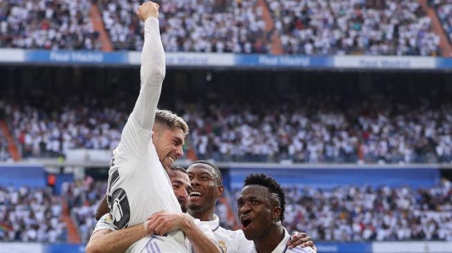 Gelandang Real Madrid, Fede Valverde (atas) melakukan selebrasi usai mencetak gol ke gawang Barcelona pada laga Liga Spanyol di Santiago Bernabeu, Minggu (16/10/2022) malam WIB. [THOMAS COEX / AFP]